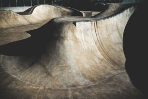 Tom betongpark med böljande skateytor och djupa bowls