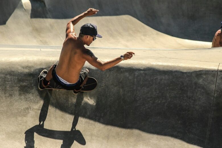 Skateboardåkare i luften över kanten på en betongbowl